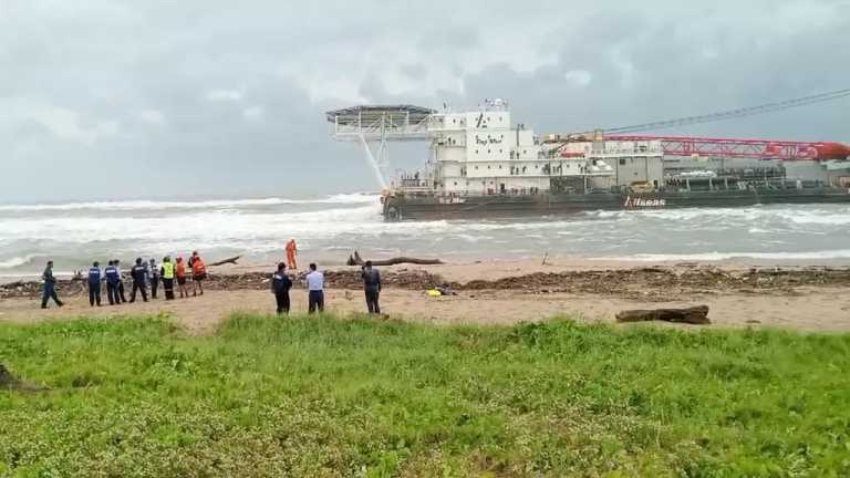 Marina resguardan la embarcación "Tog Mor" que encalló en la playa de Villa Allende, en el puerto de Coatzacoalcos, mientras son buzos trabajan para poner el tierra firme la barcaza.