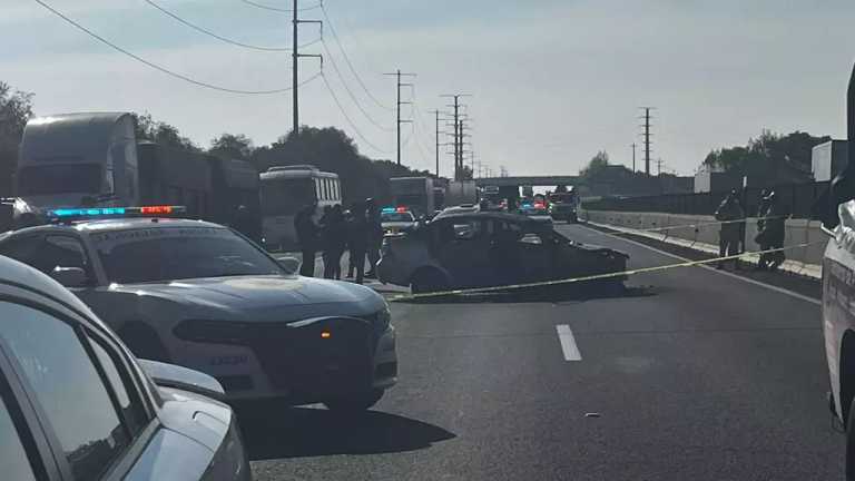 Guardia Nacional, Seguridad Pública y Fiscalía de Puebla resguardan la zona donde hallaron restos humanos en un auto sobre la Autopista México-Puebla.