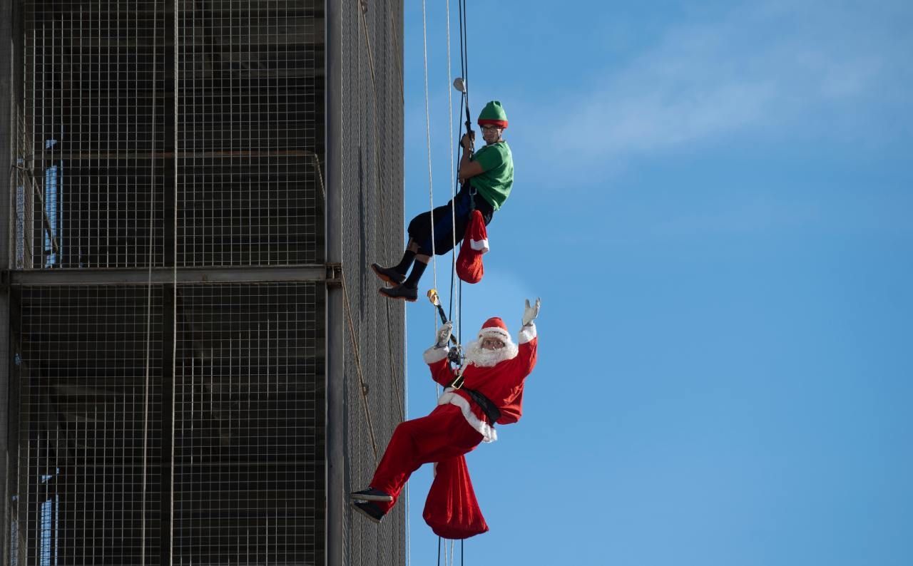 Un hombre disfrazado de Santa Claus desciende de un edificio en Barcelona.