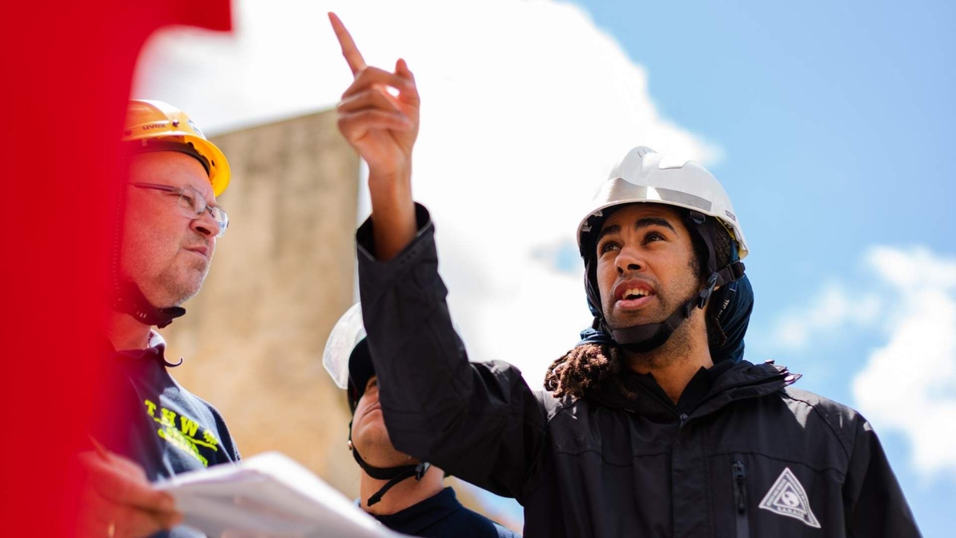 Un ingeniero da instrucciones a sus compañeros durante una construcción