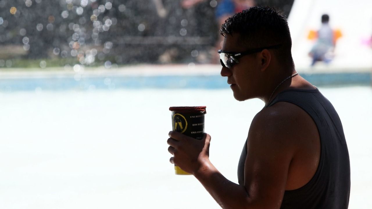 Un joven se refresca tomando una cerveza