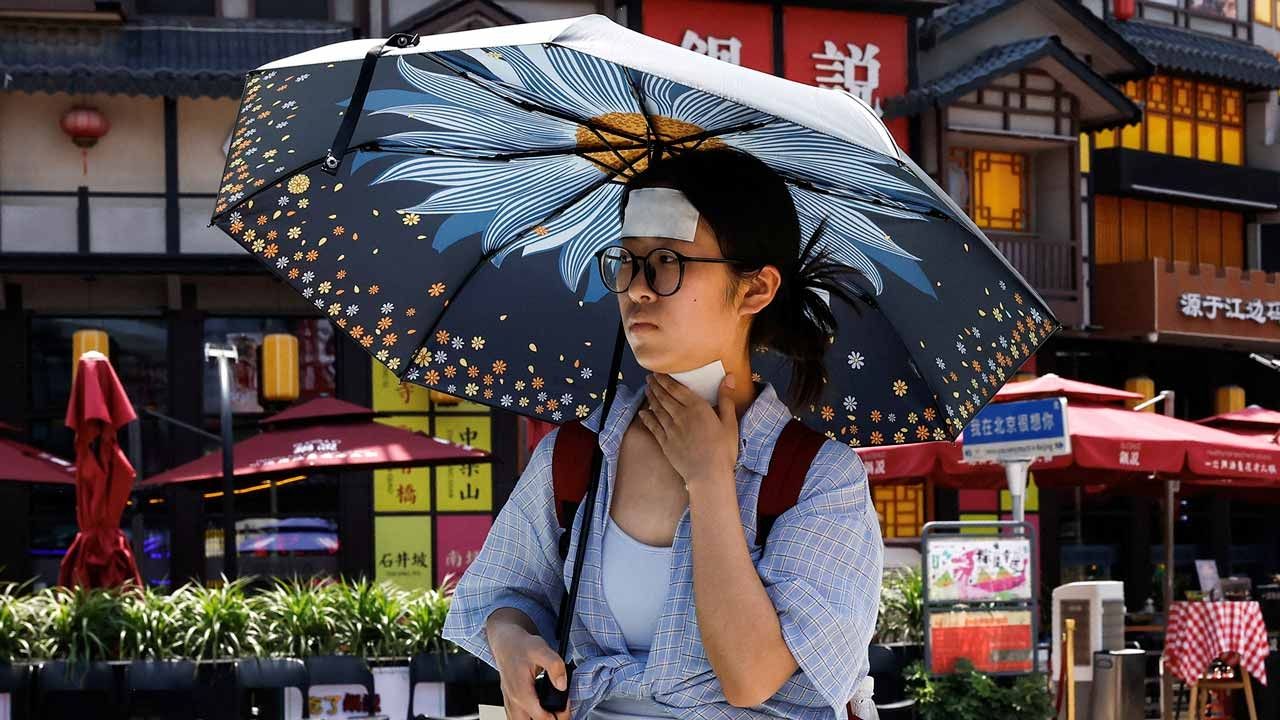 La gente se protege del calor en China, el 24 de junio de 2023. Foto: AFP | Archivo