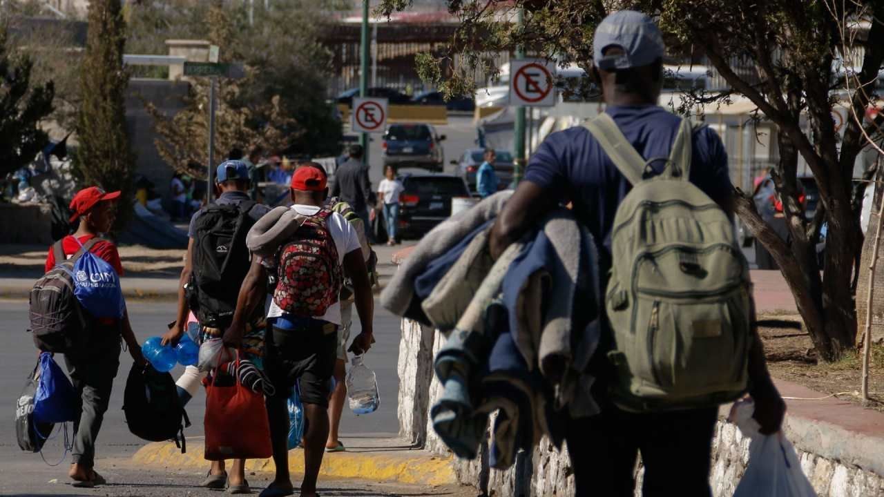 Migrantes caminan hacia un albergue en Chihuahua