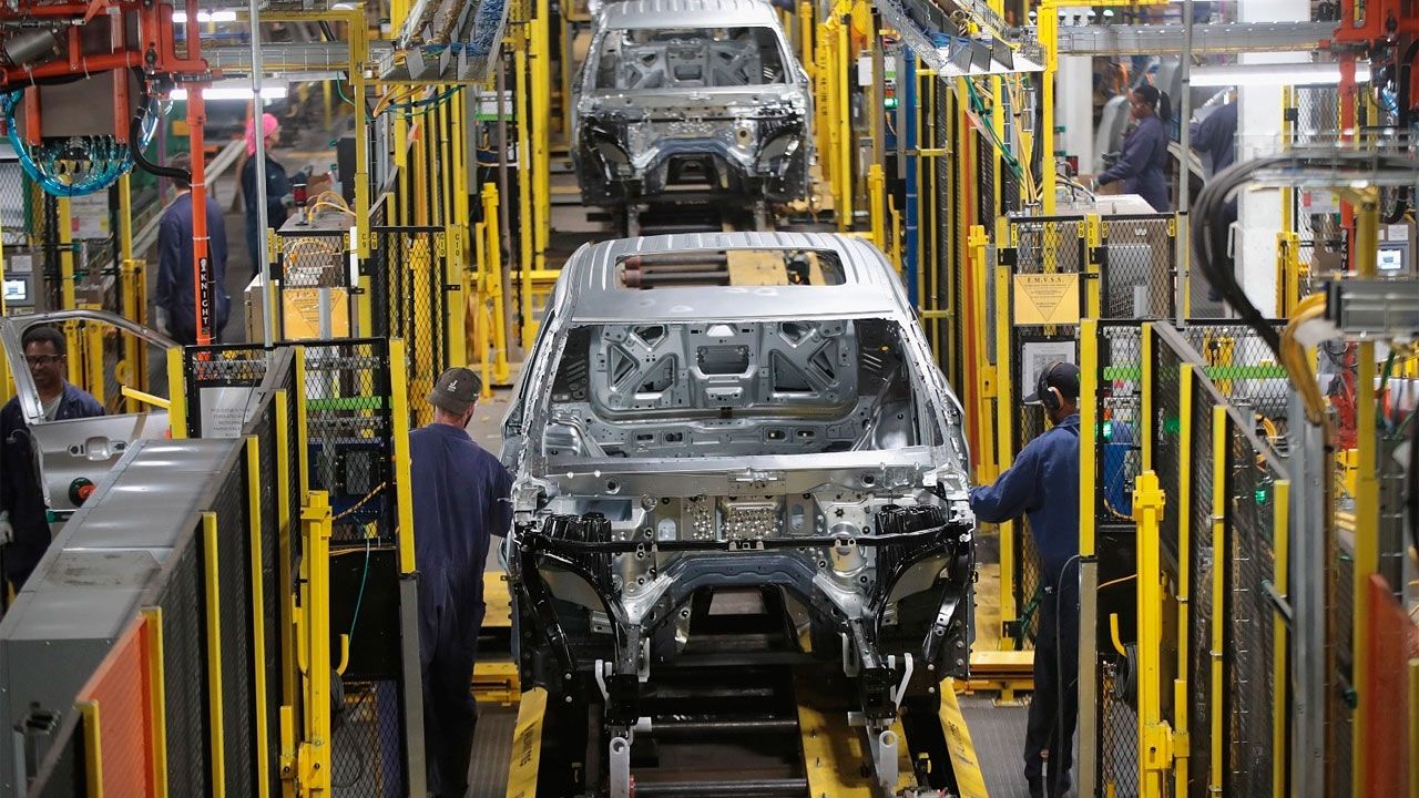 Operarios trabajando en una moderna línea de ensamblaje en la industria automotriz mexicana