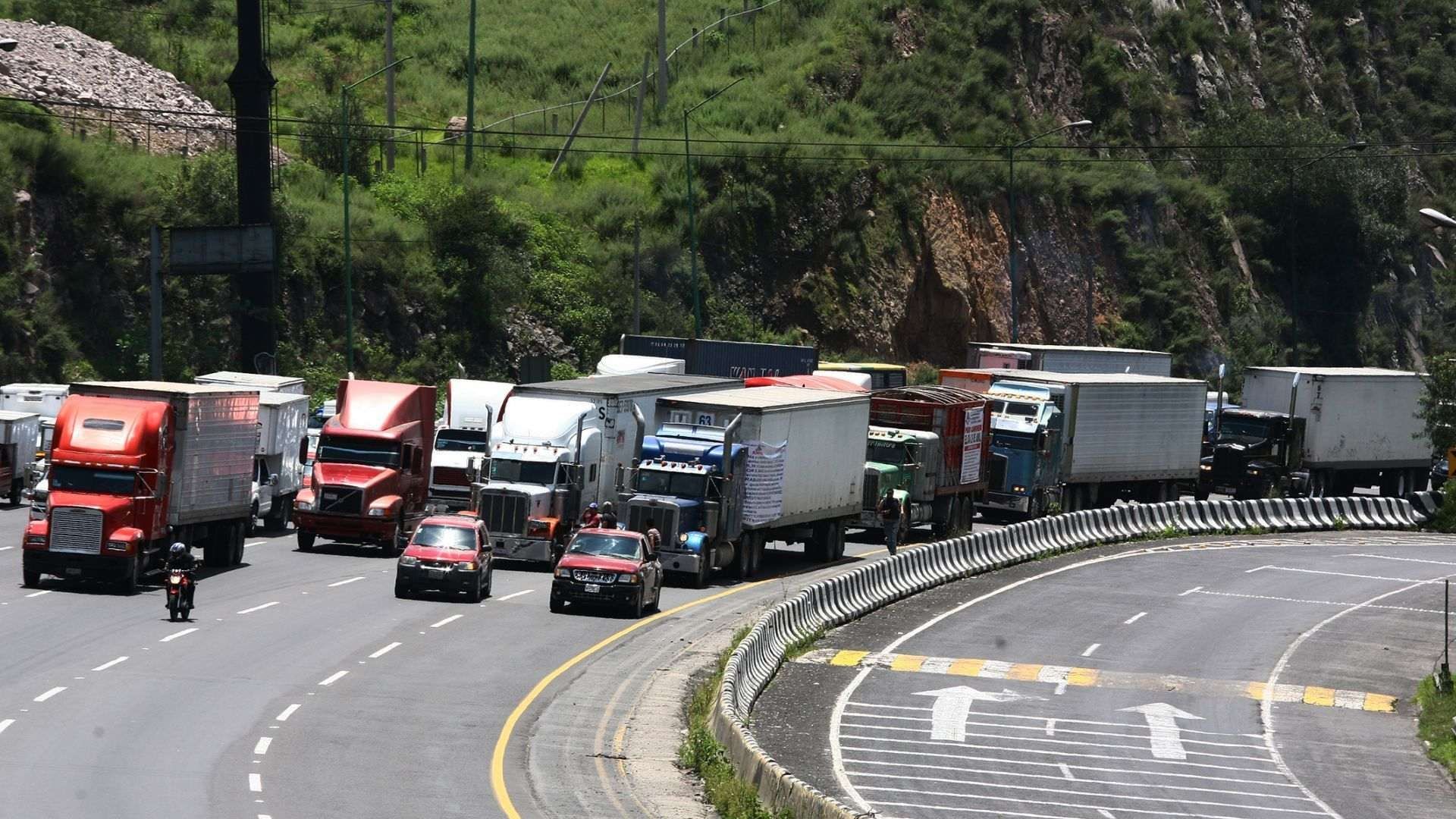 Camiones de carga y transportistas sobre la Autopista México-Querétaro