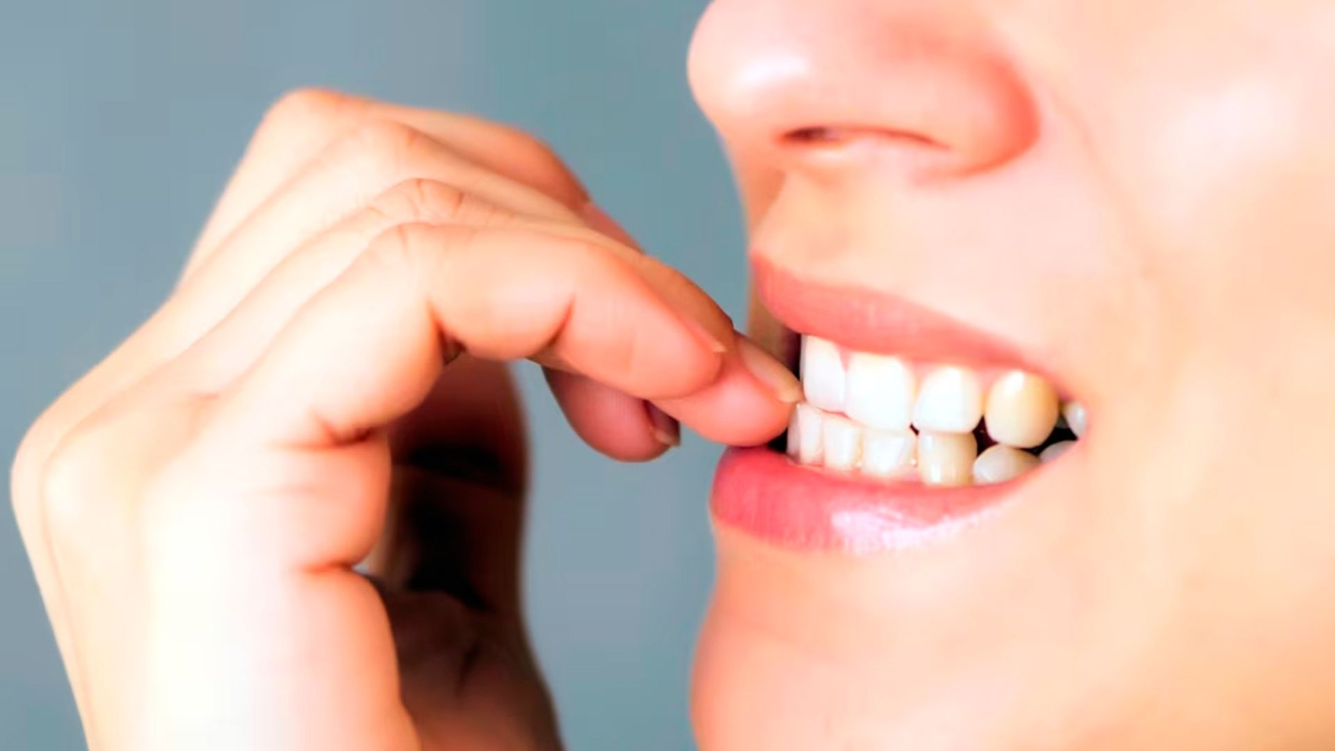 Mujer mordiéndose las uñas preocupadamente