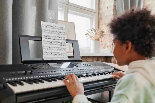 Niño ensaya piano frente a una partitura